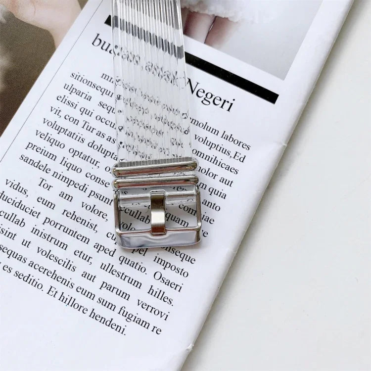 transparent TPU watchband for Apple Watch resting on a magazine page featuring a silver buckle design.
